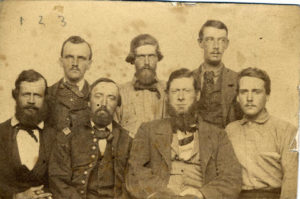 Old photograph of a group of men sitting.