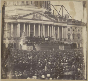Capital Building in background with a large crowd in foreground of the sepia tone photograph.